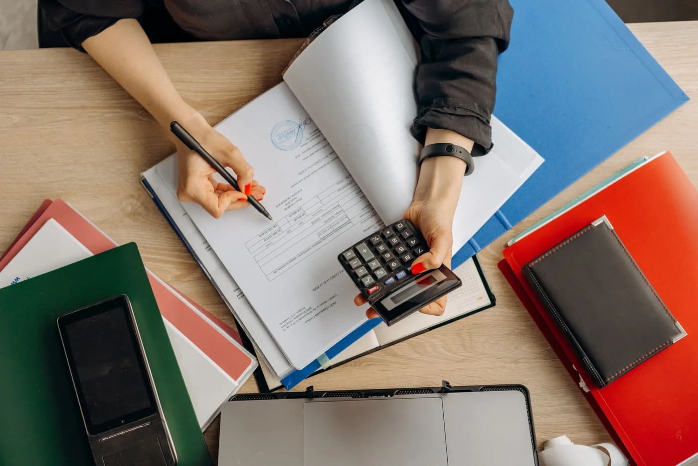 A professional reviewing financial documents at a desk.