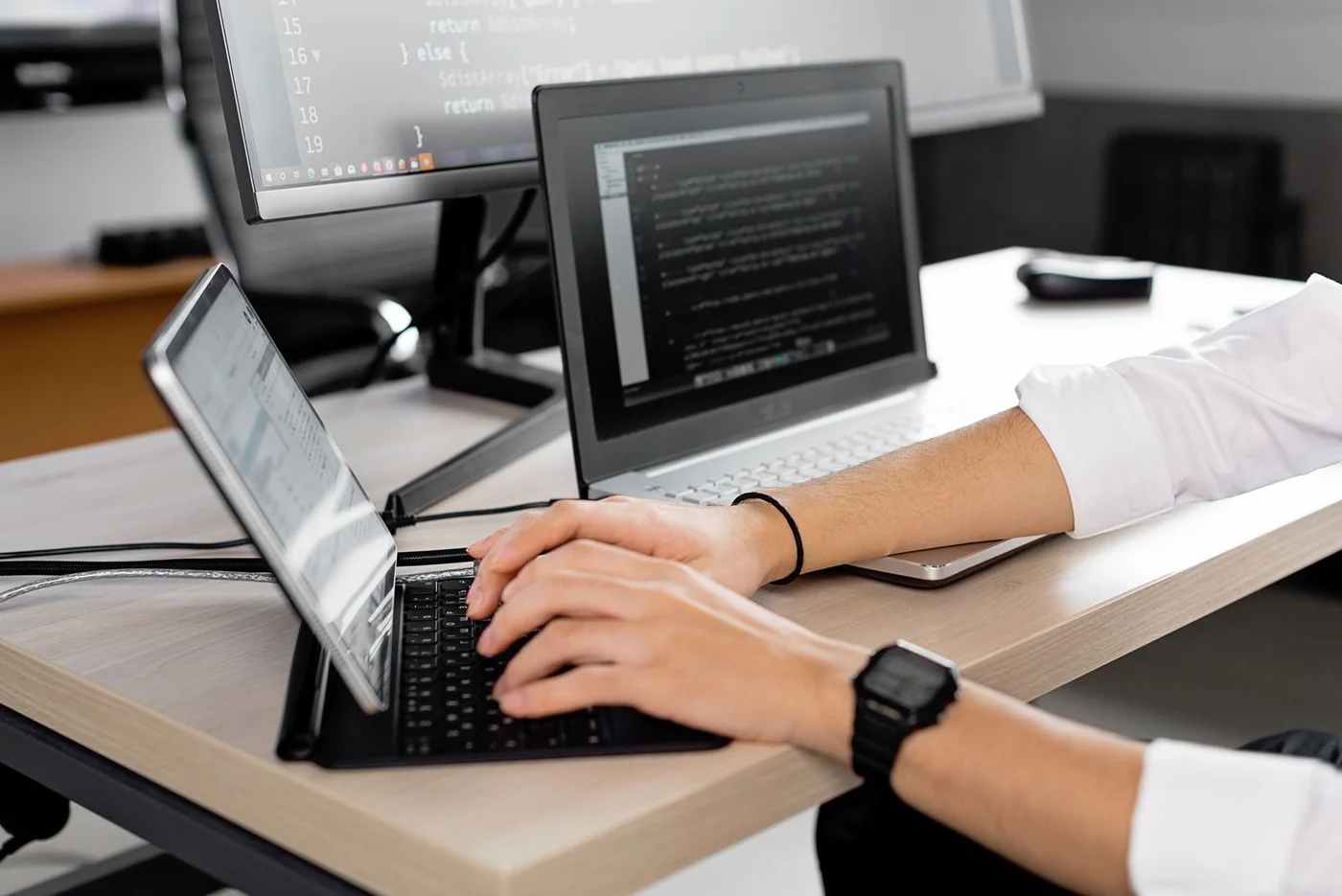 A programmer working across multiple monitors.