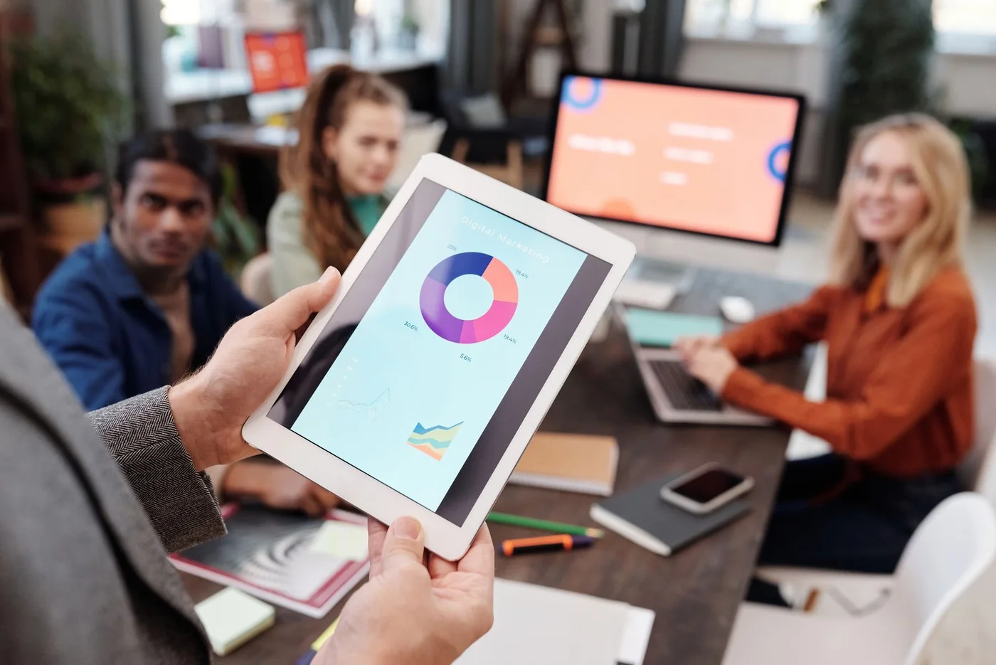 Colleagues reviewing marketing charts on a tablet.